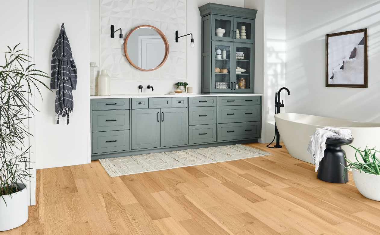 Engineered hardwood floor in white bathroom w/standing tub.